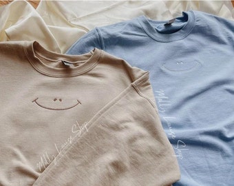 Sudadera con cara sonriente bordada