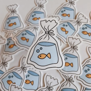 May include: A collection of stickers featuring a cartoon illustration of a goldfish in a plastic bag. The stickers are white with blue and orange accents.