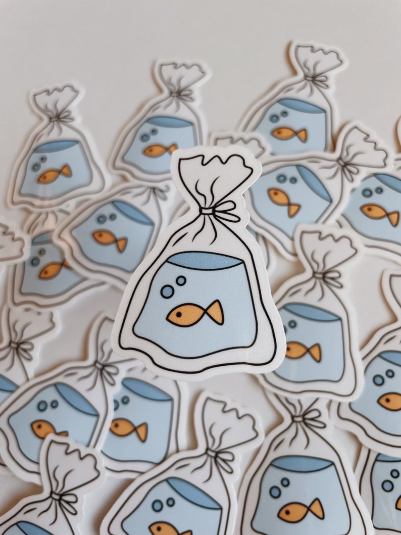 May include: A collection of stickers featuring a cartoon illustration of a goldfish in a plastic bag. The stickers are white with blue and orange accents.