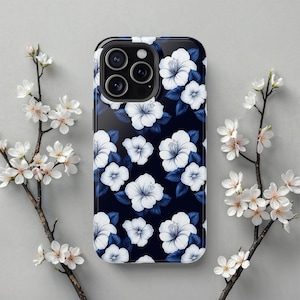 May include: A navy blue phone case with a white floral pattern. The case has a cutout for the camera lens.