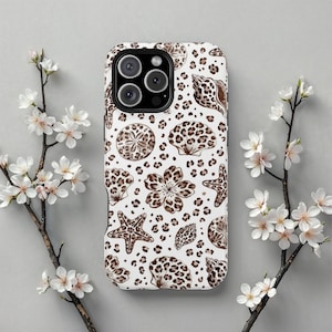 May include: White phone case featuring a repeating pattern of seashells, starfish, and floral designs in brown leopard print. The case has a black camera module. White flowers surround the case.