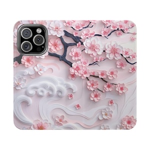 May include: A phone case featuring a 3D floral design with pink cherry blossoms and dark gray branches. The case has a light pink background with white wave-like patterns.