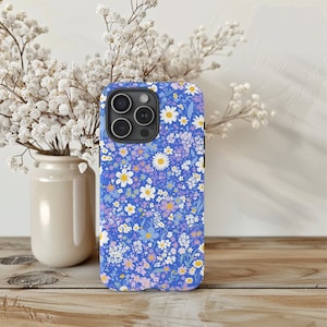 May include: A blue phone case with a white and purple floral pattern. The case has a cutout for the camera lens.