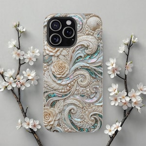 Könnte beinhalten: Dekorative Handyhülle mit einem geschnitzten Blumen- und Muscheldesign. Die Hülle hat eine cremefarbene Basis mit Perlenakzenten und schillernden Abalone-Muscheleinlagen. Die Hülle hat einen Kameraausschnitt für drei Objektive.