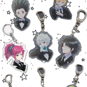 May include: A set of seven anime character keyrings. Each keyring features a different character in a black suit and tie. The keyrings are made of clear acrylic and have silver-coloured key rings.