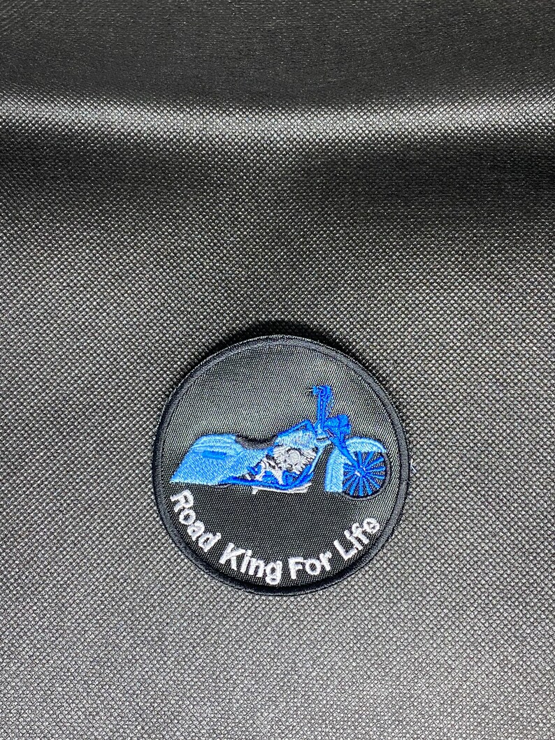 May include: A black and blue embroidered patch with a motorcycle and the text "Road King For Life".