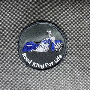 May include: A black and white embroidered patch with a blue motorcycle and the text "Road King For Life".