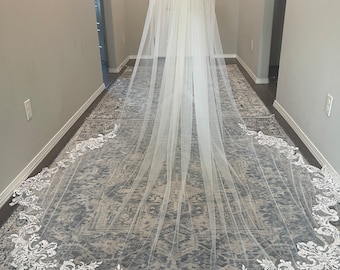 May include: A long white bridal veil with a delicate lace trim. The veil is made of soft tulle and has a cathedral length.