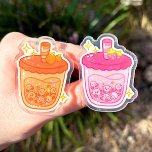 Kirb-boba holographic acrylic pins | pins, boba, kirby, poyo, acrylic, strawberry, orange, cute, sparkles, drawing, stars, gold