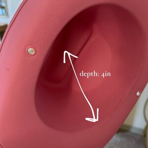 K&ouml;nnte beinhalten: Ein rosa Filzhut mit einer Tiefe von 10 cm. Der Hut hat eine breite Krempe und eine glatte Oberfl&auml;che.
