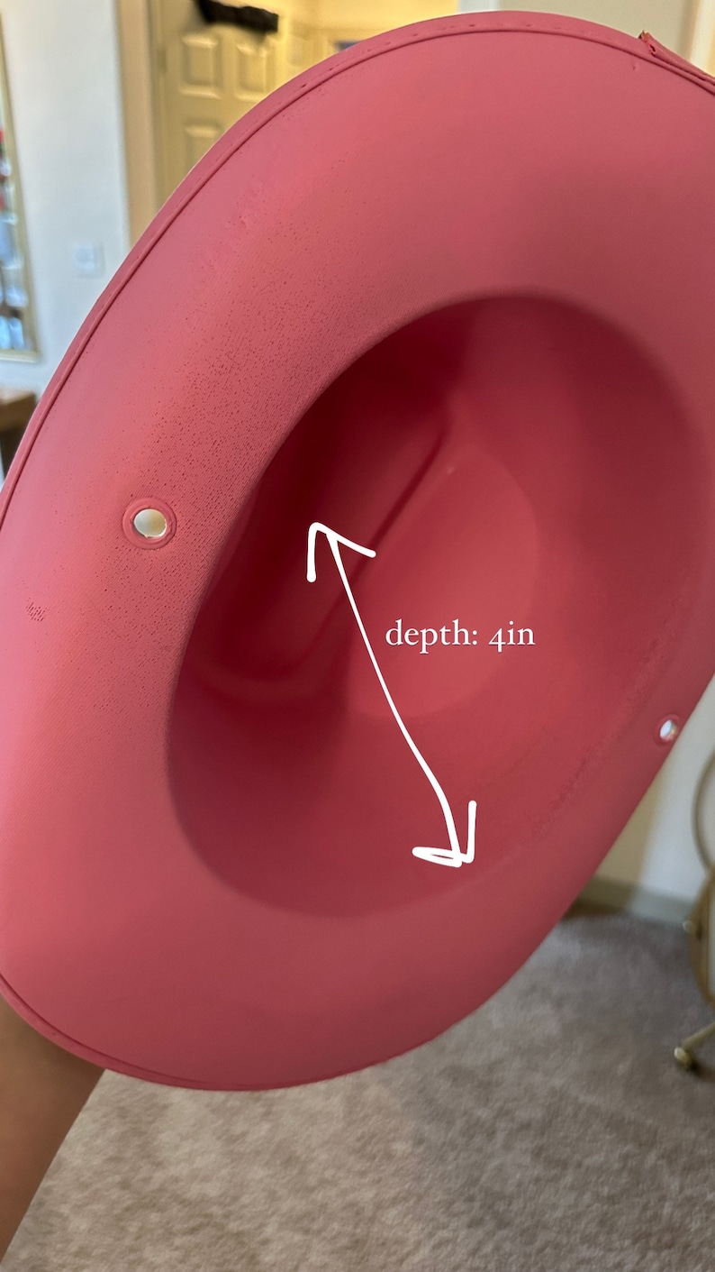 K&ouml;nnte beinhalten: Ein rosa Filzhut mit einer Tiefe von 10 cm. Der Hut hat eine breite Krempe und eine glatte Oberfl&auml;che.