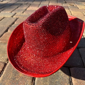 K&ouml;nnte beinhalten: Ein roter Cowboyhut, der mit funkelnden roten Strasssteinen besetzt ist.