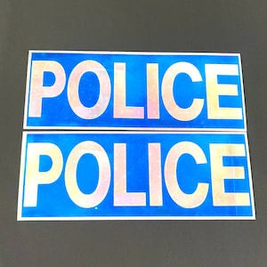 Puede incluir: Dos señales reflectantes azules con la palabra "POLICE" en letras blancas.