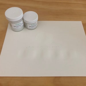 May include: Two small white plastic containers of white iridescent paint with the brand name VizGlow printed on the labels.