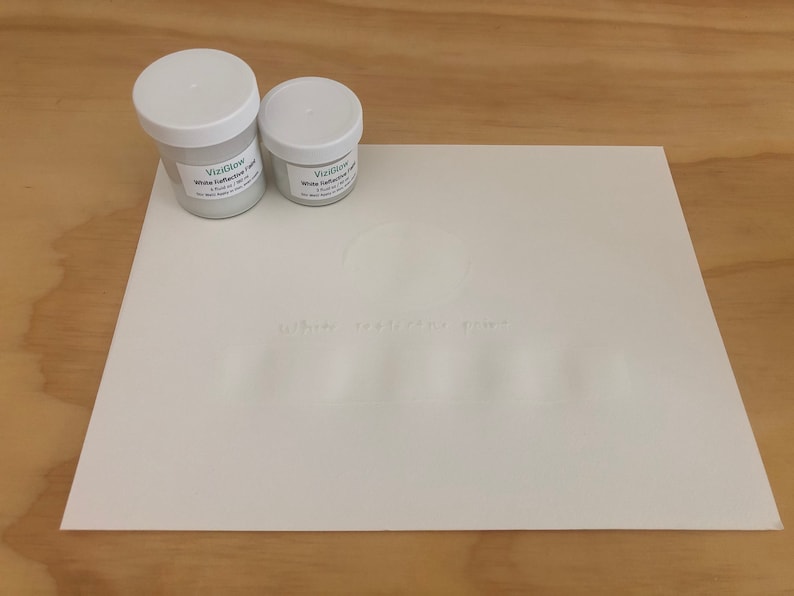 May include: Two small white plastic containers of white iridescent paint with the brand name VizGlow printed on the labels.