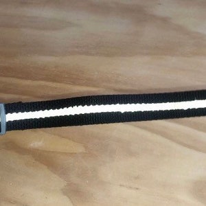 May include: Black dog collar with a white reflective strip and a plastic buckle.