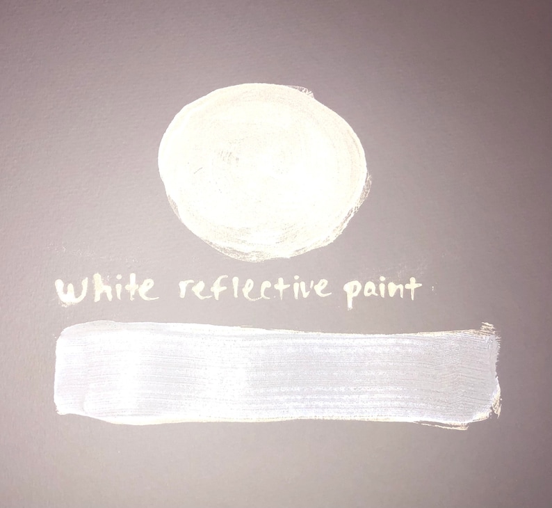 May include: White reflective paint sample. The paint is shown in a circle and a rectangle.