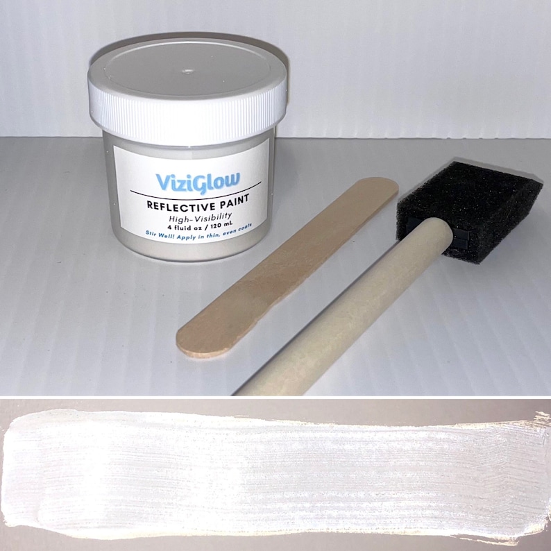 May include: A small white jar of reflective paint with a white lid and a black and white label that reads "ViziGlow Reflective Paint High-Visibility 4 fluid oz / 120 ml Stir Well! Apply in thin, even coats". The jar is accompanied by a wooden paint stirrer and a foam paint brush.