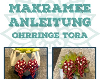 May include: Red macrame earrings with white beads, hanging from silver hooks. The earrings are displayed on a gray surface with a green succulent plant.