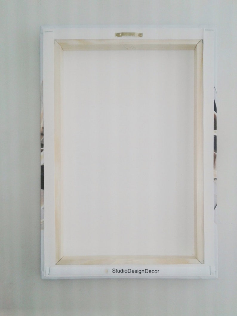 May include: White canvas print with a wooden frame. The back of the canvas has a label that reads "StudioDesignDecor".