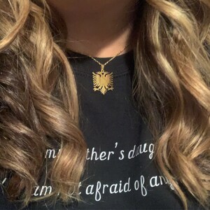 Op de afbeelding: Een gouden ketting met een hanger in de vorm van een dubbelkoppige adelaar. De adelaar is het nationale symbool van Albani&euml;.