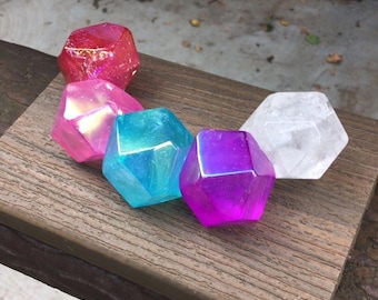 May include: Five faceted geometric crystal-like objects arranged in a semi-circle. The colors include a textured red, a translucent pink, a bright blue, a vibrant purple, and a clear white. The text LIBRA CRYSTALS appears in the top right corner.