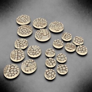 May include: A set of 17 round, beige-coloured, plastic gaming bases with a textured, cobblestone design. The bases are approximately 25mm in diameter.