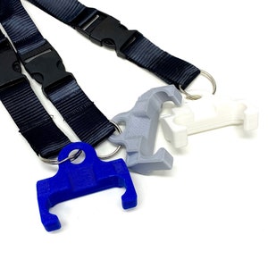 May include: A black lanyard with a blue, grey, and white plastic key chain. The key chain has a loop on one end and a hook on the other end.