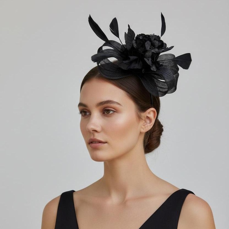 May include: A black headpiece featuring a floral design with feathers. The headpiece is worn on the head and is made of a dark material. The woman in the image is wearing a black dress.