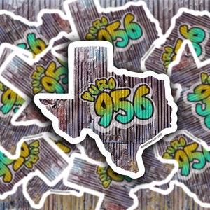 May include: Multiple stickers featuring a Texas state outline with the words "Puro 956" in yellow and green lettering on a woodgrain background.