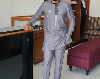 May include: A gray long-sleeved shirt with a black geometric design on the front, paired with matching gray pants and brown leather loafers.