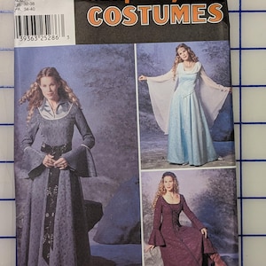 May include: A Simplicity Costumes sewing pattern envelope, number 9891, featuring illustrations of three long-sleeved dresses with flared cuffs and varied necklines. The package includes size information 6, 8, 10, 12 and the brand name Wrights.