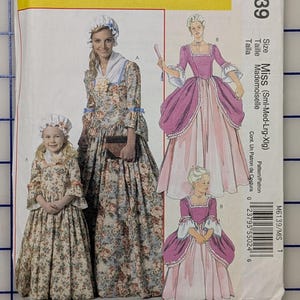 May include: McCall's Costumes sewing pattern M6139 featuring historical dress designs. The pattern includes illustrations of women's and girl's dresses with floral and solid color fabrics. The pattern size is Miss (Sml-Med-Lrg-Xlg).