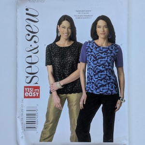 May include: A sewing pattern titled "B6157" featuring two women modeling tops and pants. One woman wears a black lace top and gold pants, the other a blue and black patterned top and black pants. The pattern includes the text "YES! It's easy."