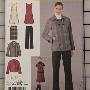 May include: A Simplicity 2868 sewing pattern envelope for easy chic clothing. The front displays illustrations of a sleeveless dress, a skirt, trousers, and two double-breasted jackets. A photograph shows a plaid jacket and dark trousers.