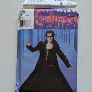 May include: Simplicity costume pattern for adults, size R5. The package features a person in a long black coat with a lace-up front and sunglasses. The package has the number 380 and the text "Costumes for adults".
