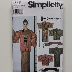 May include: Simplicity sewing pattern 5839 featuring June Colburn Designs. The pattern includes instructions for making a kimono. The package shows a woman wearing a kimono with a floral design. Sizes XS, S, M, L, XL.