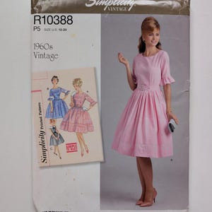 May include: Simplicity Vintage sewing pattern R10388, size U.S. 12-20. The pattern features a 1960s vintage dress design. The image shows a pink dress with a belt and a woman wearing the dress. The pattern includes illustrations of the dress.