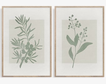 May include: Two framed prints with botanical illustrations. The prints feature a green silhouette of a leafy branch with berries on a light beige background.