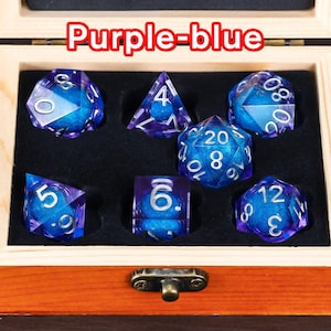 May include: A set of seven purple-blue dice with silver numbers in a wooden box. The dice are in a variety of shapes and sizes, including a d4, d6, d8, d10, d12, and d20.