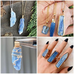 May include: Three gold necklaces with blue kyanite crystal pendants. The pendants are different shapes and sizes. The necklaces are on a wooden surface with green foliage.