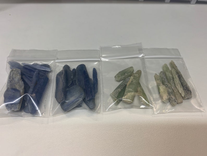 May include: Four small plastic bags containing various types of blue and green crystals. The crystals are in various shapes and sizes.