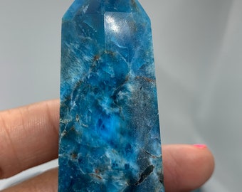 May include: A blue and white crystal point with a pointed tip and a smooth, polished surface.