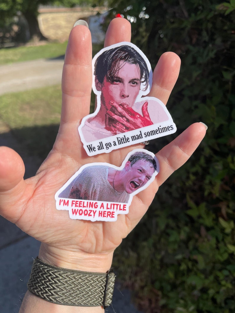 May include: Two stickers featuring images of a man from the movie American Psycho. The top sticker shows the man with blood on his hand and the text "We all go a little mad sometimes". The bottom sticker shows the man with blood on his face and the text "I'm feeling a little woozy here".