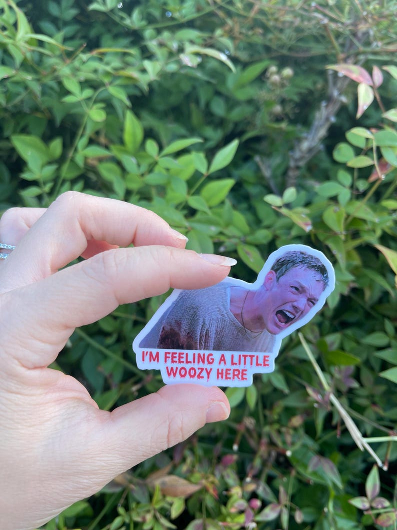 May include: A white sticker with a photo of a man with a shocked expression. The sticker has red text that says "I'm feeling a little woozy here."