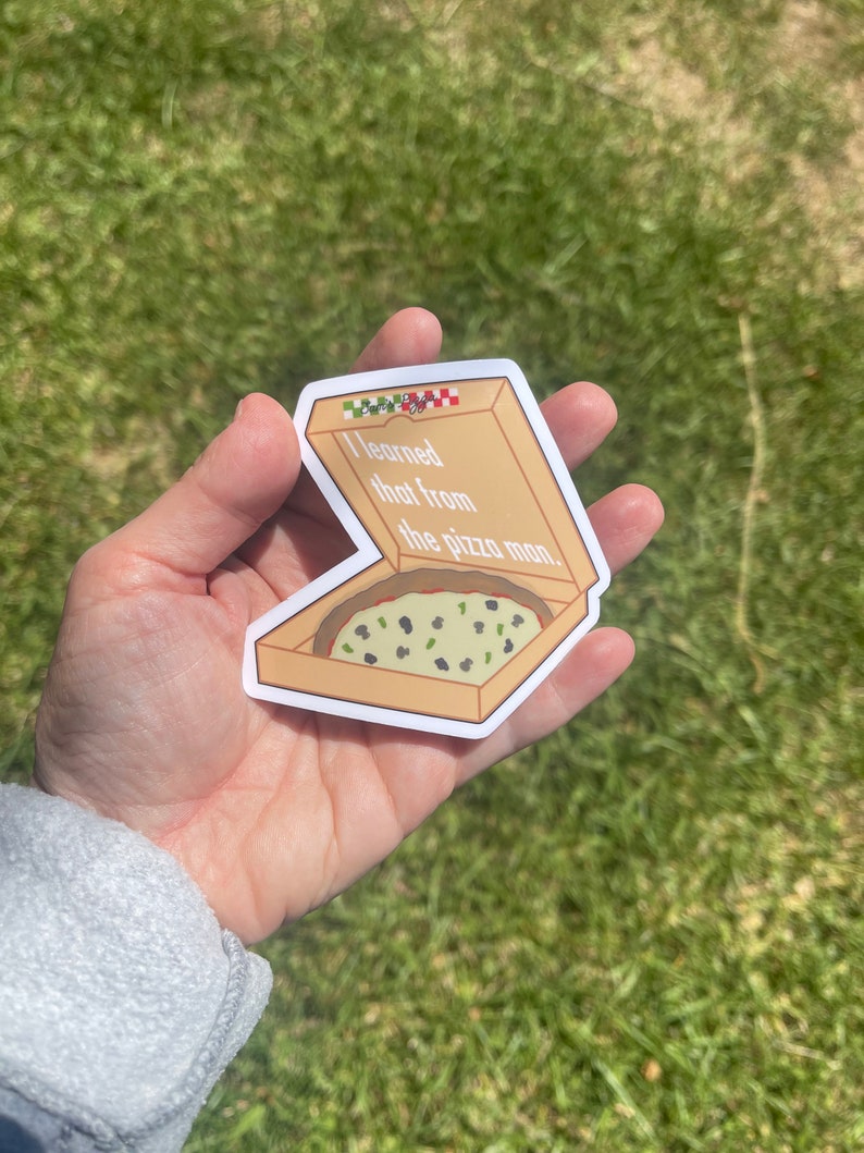 Puede incluir: Una pegatina de una caja de pizza con una rebanada de pizza dentro. La caja es marr&oacute;n con un patr&oacute;n de cuadros rojos y verdes en la parte superior. El texto en la pegatina dice "Aprend&iacute; eso del repartidor de pizza."
