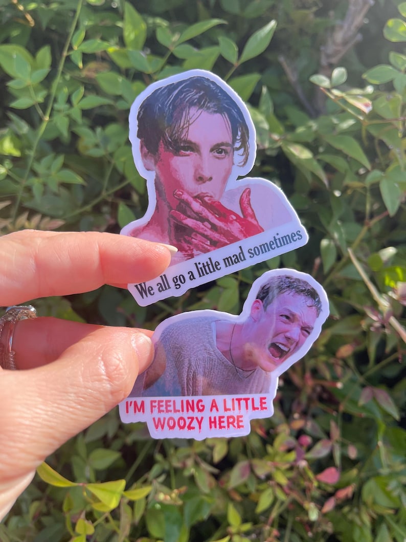 May include: Two stickers featuring images of actors from the movie "American Psycho". The top sticker features a close-up of Patrick Bateman with blood on his hands and the text "We all go a little mad sometimes". The bottom sticker features a close-up of Paul Allen with a distressed expression and the text "I'm feeling a little woozy here".