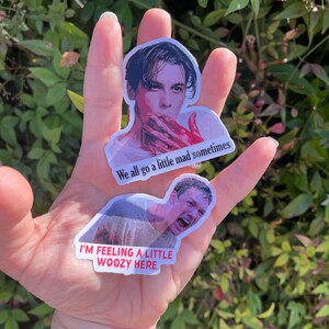 May include: Two stickers featuring images of actors from the movie "The Cabin in the Woods." The first sticker shows a man with blood on his face and the text "We all go a little mad sometimes." The second sticker shows a man with a shocked expression and the text "I'm feeling a little woozy here."