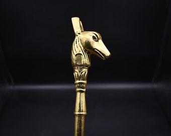 Puede incluir: Una manija decorativa de metal dorado con un diseño detallado de una cabeza de animal. La manija es probablemente para una puerta o un armario.