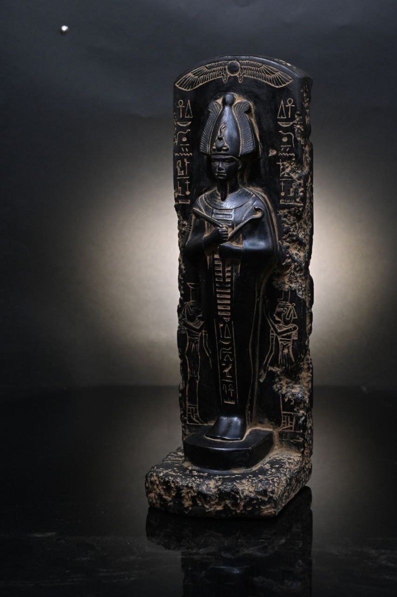 Puede incluir: Estatua de piedra negra de un fara&oacute;n egipcio con jerogl&iacute;ficos tallados en la piedra. El fara&oacute;n lleva un alto tocado y una larga t&uacute;nica.